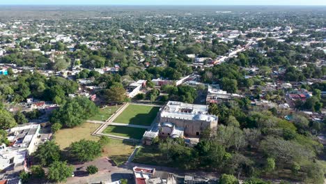 high aerial push in and tilt down to the convent de san bernardino in valladolid, yucatan, mexico in early morning