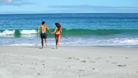 una pareja sonriente corriendo juntos.