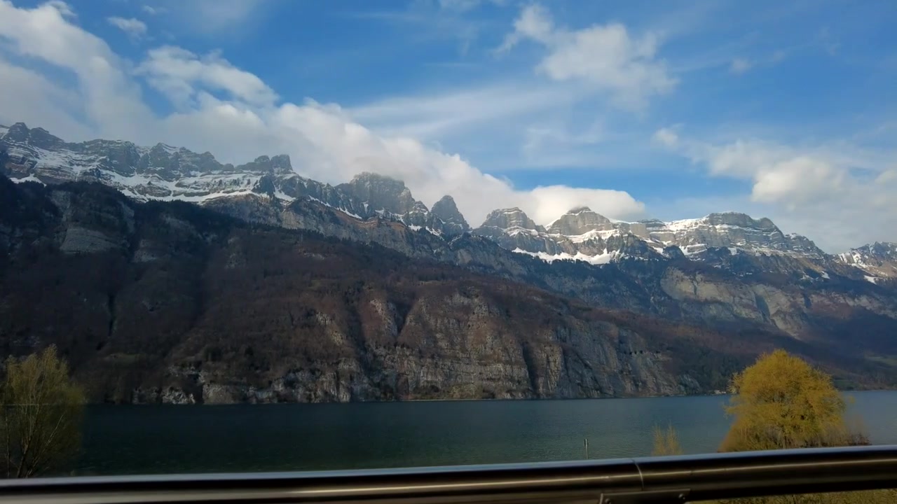 Pitkä panorointi-timelapse parvekkeelta seuraa Walenseen ja pilvien peittämien huippujen yli.