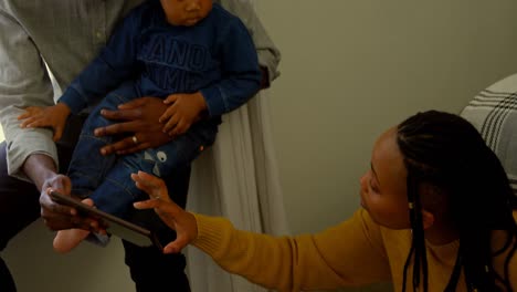 Front-view-of-young-black-family-using-digital-tablet-in-a-comfortable-home-4k