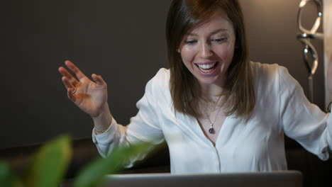 una mujer profesional exitosa trabajando en una computadora ganando y celebrando