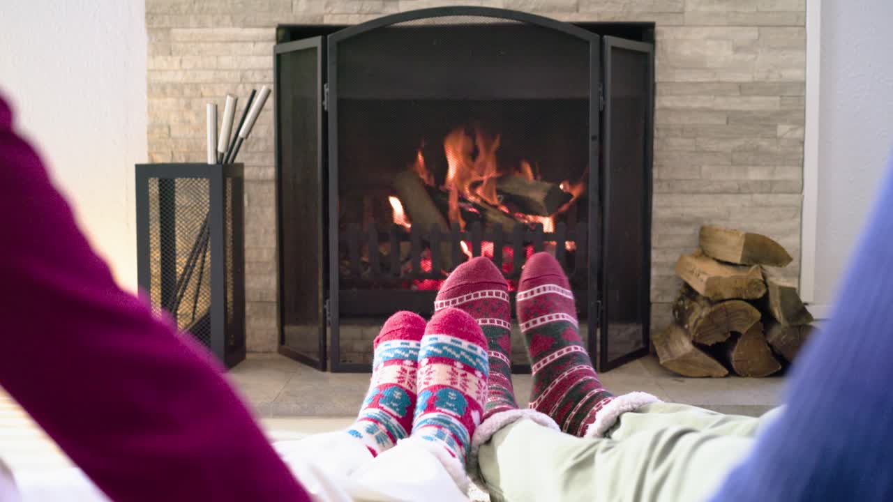 Camera panning upward as couple interlacing fingers on rug, lifting torsos and gazing at fireplace