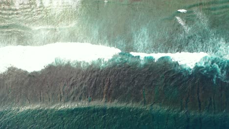 white waves of blue turquoise water of ocean, splashing and foaming on sandy shore of tropical island in cambodia