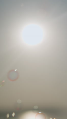 close-up of colorful bubbles floating gracefully in the air under a bright sun, creating a dreamy, ethereal scene with light rays piercing through the bubbles, enhancing the magical atmosphere