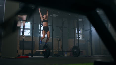 slow motion: raising feet up to bar on gym bar attractive muscle woman exercise and train in gym. female athlete standing on a horizontal bar lifts her legs to train the muscles of the abs