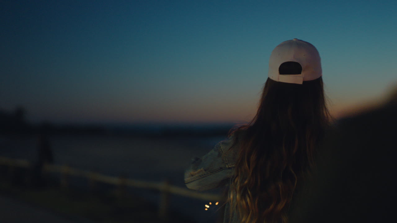 線香花火で遊ぶ若い女性が友人と大晦日を祝い、線香花火で楽しい夜を過ごし、夜のお祝いを共有する