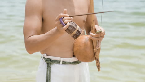 un homme sans chemise jouant d'un instrument