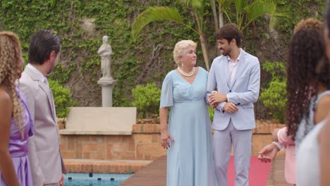 groom and mother walking down aisle at outdoor wedding ceremony