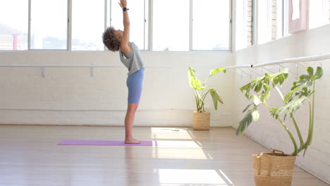 Biracial-Junge-Frau-Streckt-Sich-Im-Yogastudio