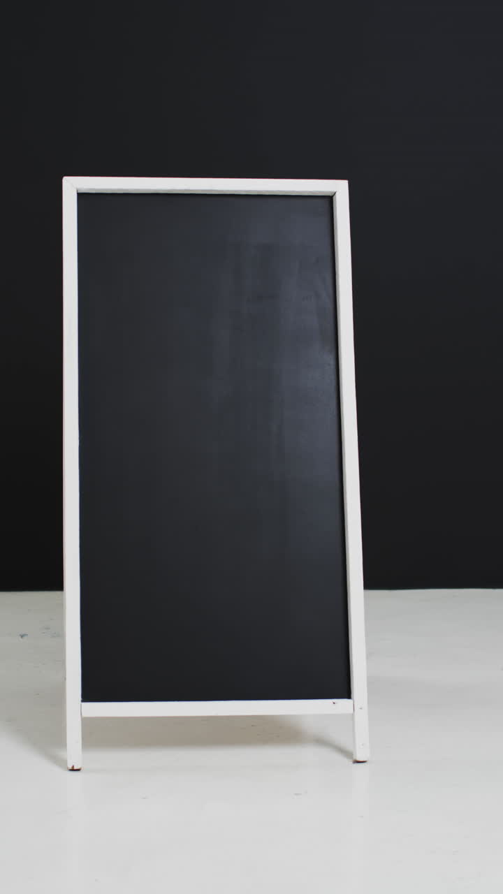 Video verticale di lavagna con spazio per il testo su supporto bianco e sfondo nero.