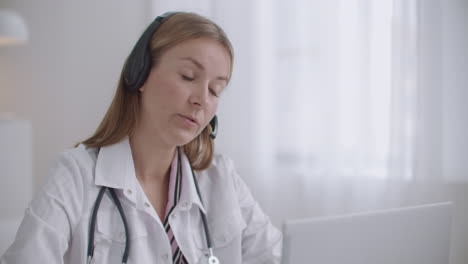 health professional woman is consulting patients by telephone using headphones with microphone distant consultation