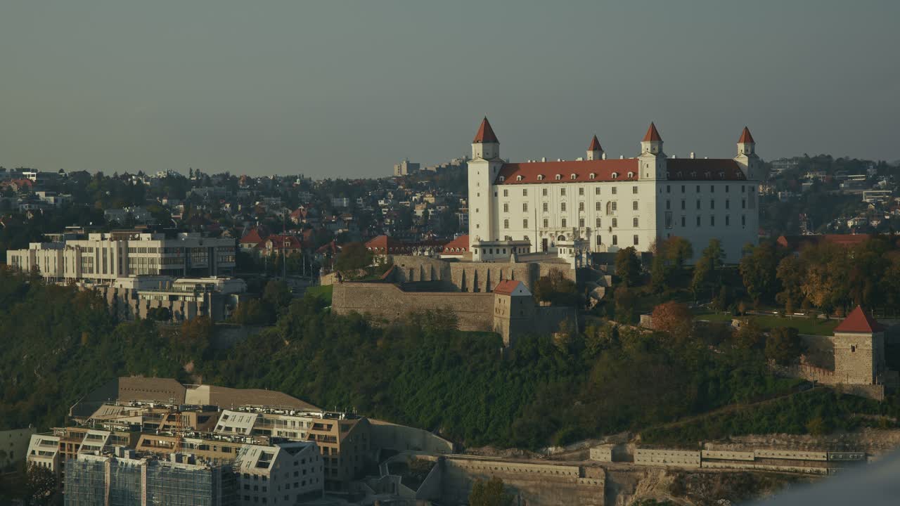 Bratislava Castle stands atop a hill, bathed in golden sunlight over the city