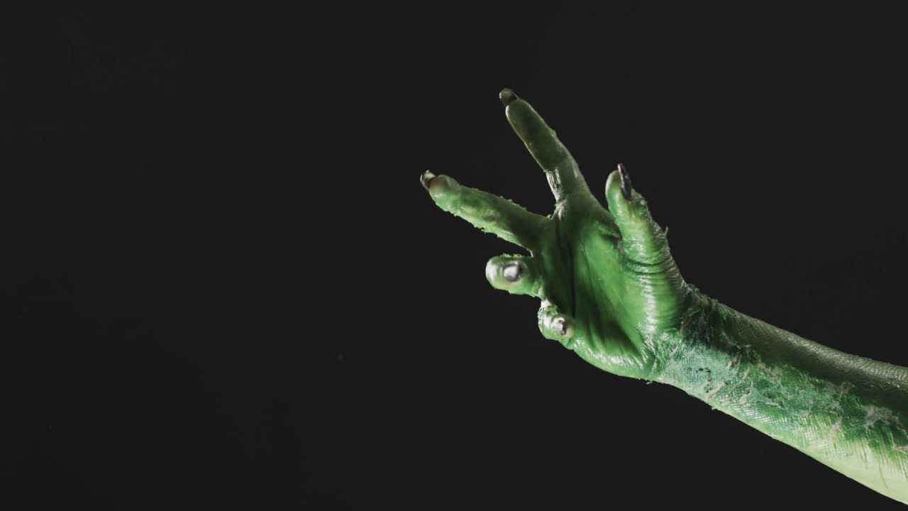 video de la mano del monstruo verde de halloween con espacio de copia en fondo negro