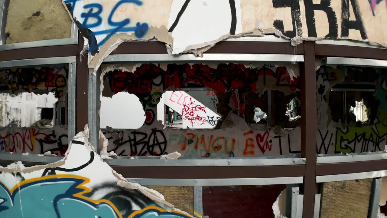 Drone che attraversa le finestre di un luogo abbandonato e in rovina con graffiti.