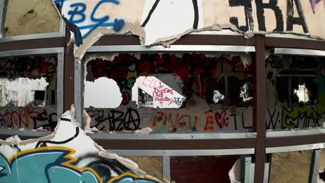 drone going through the windows of an abandoned and ruined place with graffiti