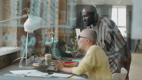 multiethnic coworkers discussing project on computer in office