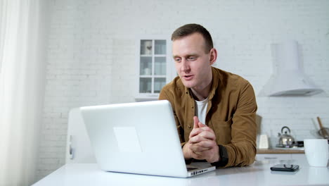 freelancer working on laptop at home. young businessman sitting at table at home working on laptop