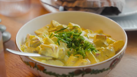 ensalada de curry cremosa adornada con cebolla en un cuenco en el julefrokost escandinavo