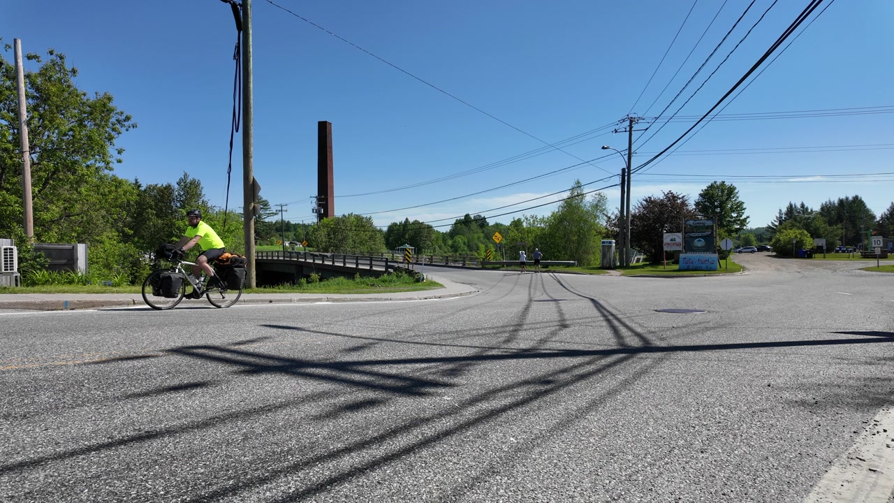 Cicloturista che pedala su strada a Scotstown, Quebec, Canada.