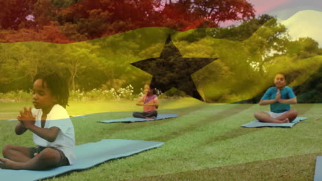 animation of flag of ghana over diverse children doing yoga in park