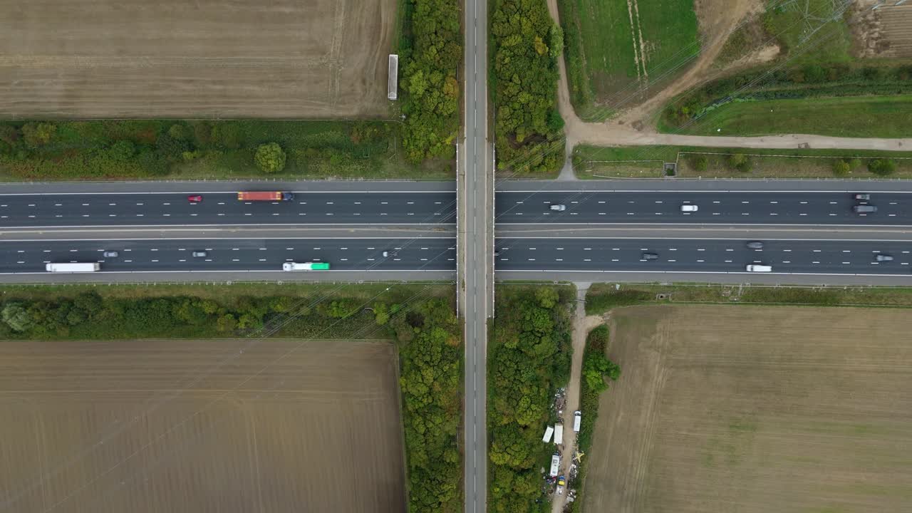 Top down aerial view of bridge crossing busy motorway and powerline cables in Yorkshire UK
