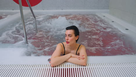 mujer relajándose en una bañera de agua caliente