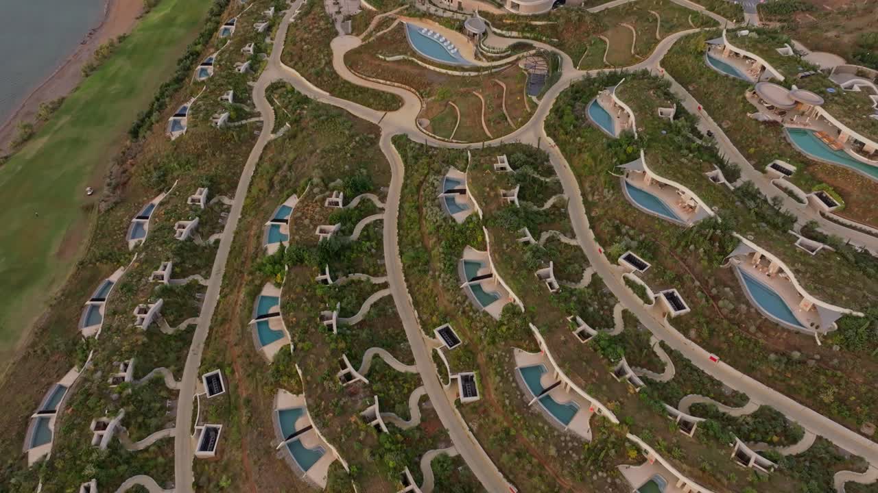 Vista aerea da drone che riprende un resort costiero e rigogliosi campi da golf