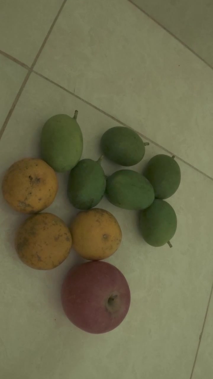 Frutta fresca assortita disposta su un pavimento piastrellato