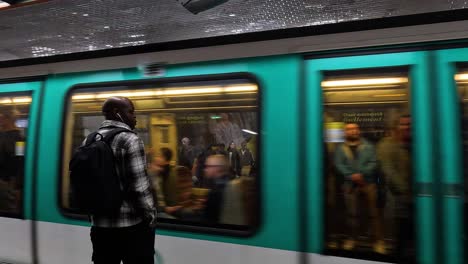 a person observes a moving train at a metro station.