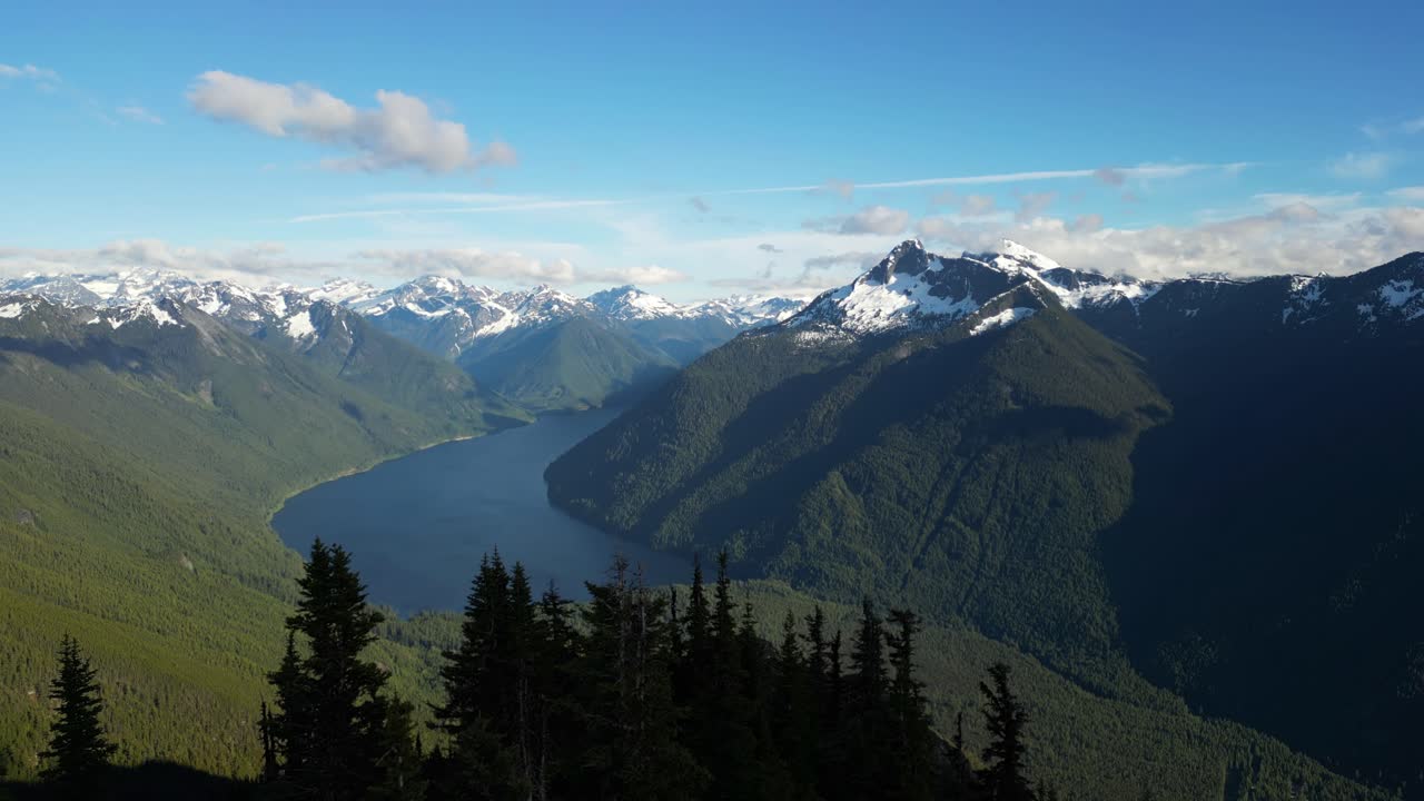 Scenic Lake surrounded by Mountains and trees. Sunny day, blue sky and clouds. Summer season. British Columbia, Canada.