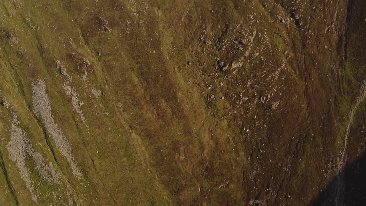 Drone top down bird's eye view of mountain slopes of Slieve Donard, vibrant grassy hillslope
