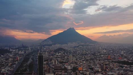 stunning red sunset behind tall mountain and urban setting of monterrey, nuevo leon, mexico in foreground