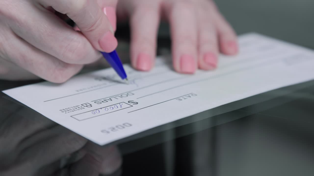mujer de negocios firma y llena un cheque bancario por mil mil dólares