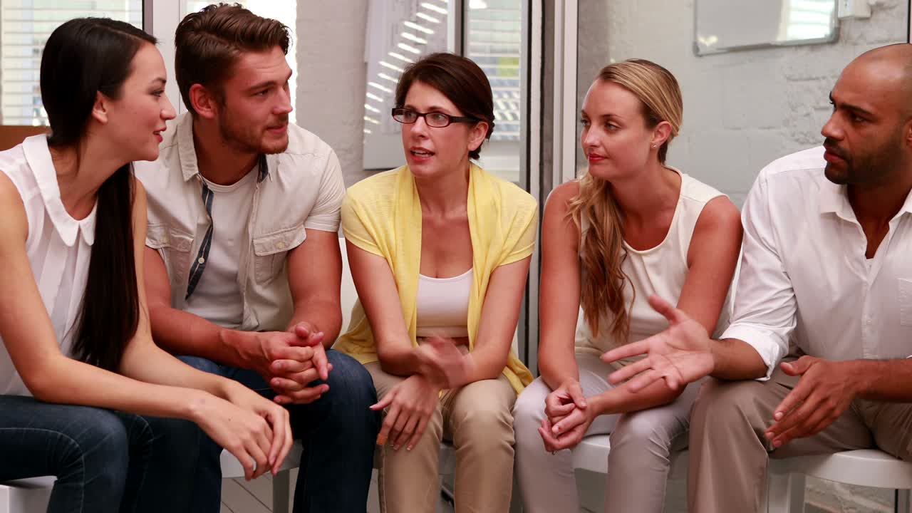 캐주얼 비즈니스 팀이 원으로 함께 이야기하고 있습니다.