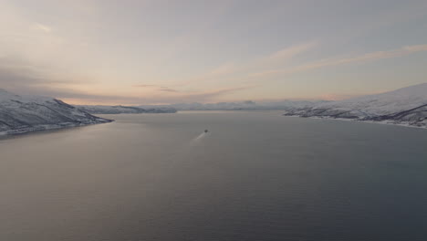 Buque-De-Carga-En-El-Fiordo-Al-Atardecer,-Paisaje-Invernal-Blanco-En-Noruega