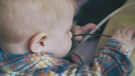 carefree baby plays with electric devices and cables