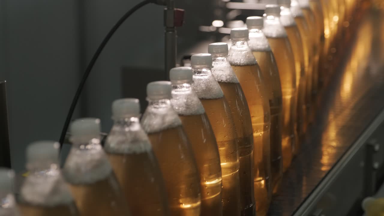 cinta transportadora con botellas para jugo o agua en una planta moderna de bebidas. producción moderna de agua dulce soda