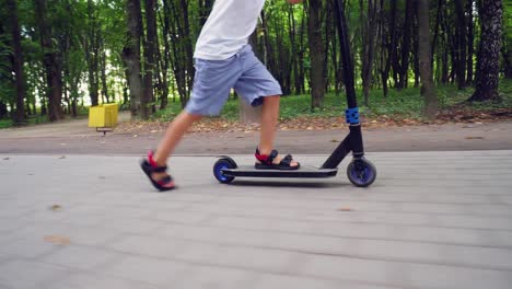 a boy rides a scooter in a city park 12