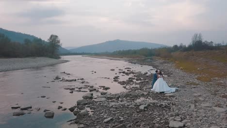 la pareja de bodas está cerca del río de la montaña. el novio y la novia.