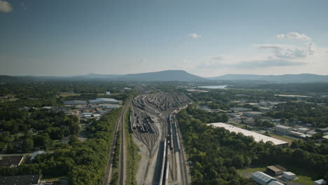 Aerial-hyperlapse-of-the-trainyard-in-Chattanooga,-Tennessee-with-Lookout-Mountain-in-the-background