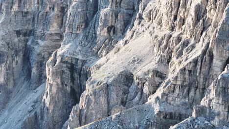 close-up view of the dolomites' majestic rock formations captured in a tele scene, showcasing the intricate details of the stratified cliffs amidst a hazy backdrop