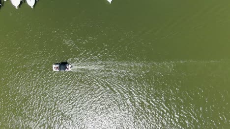 AERIAL-DIRECTLY-ABOVE-A-Small-Boat-Moving-Down-A-River