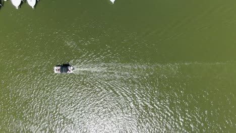 aerial directly above a small boat moving down a river