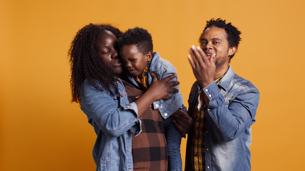 Smiling loving young family with a small cute toddler blowing air kisses