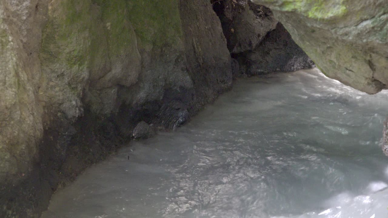 Serene Mountain Stream Flowing Through Dark Rocks