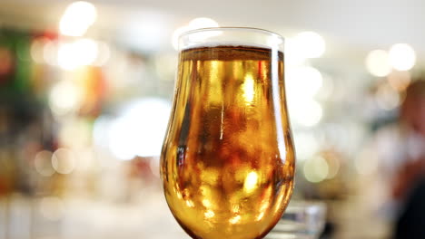 close up of glass of beer on bar counter