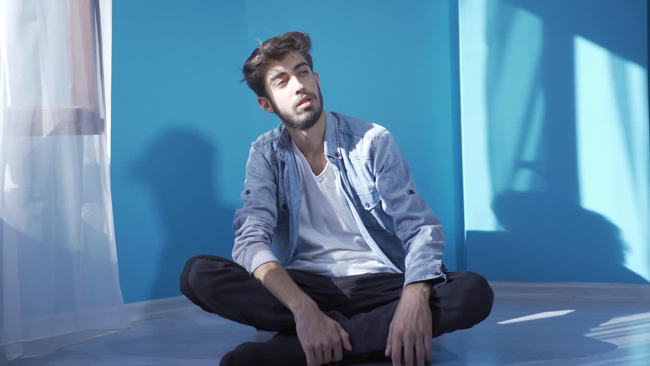 hombre deprimido. se sienta junto a la pared.