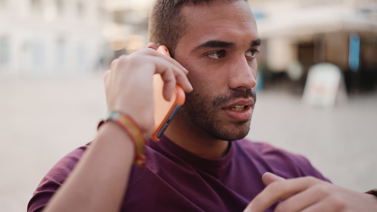 un joven con una llamada sentado en un café.