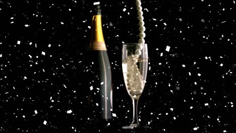 Confetti-falling-over-pearl-beads-falling-in-champagne-glass-against-black-background