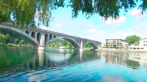 Pont-du-Chemin-de-Fer,-railway-bridge-at-Huy-on-a-summer-day-with-a-barge,-The-Maas-in-Huy,-Belgium,-4k,-50fps